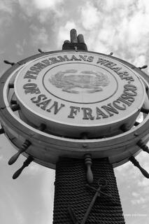 Fisherman’s Wharf sign surrounded by colorful shops and visitors along the San Francisco waterfront.