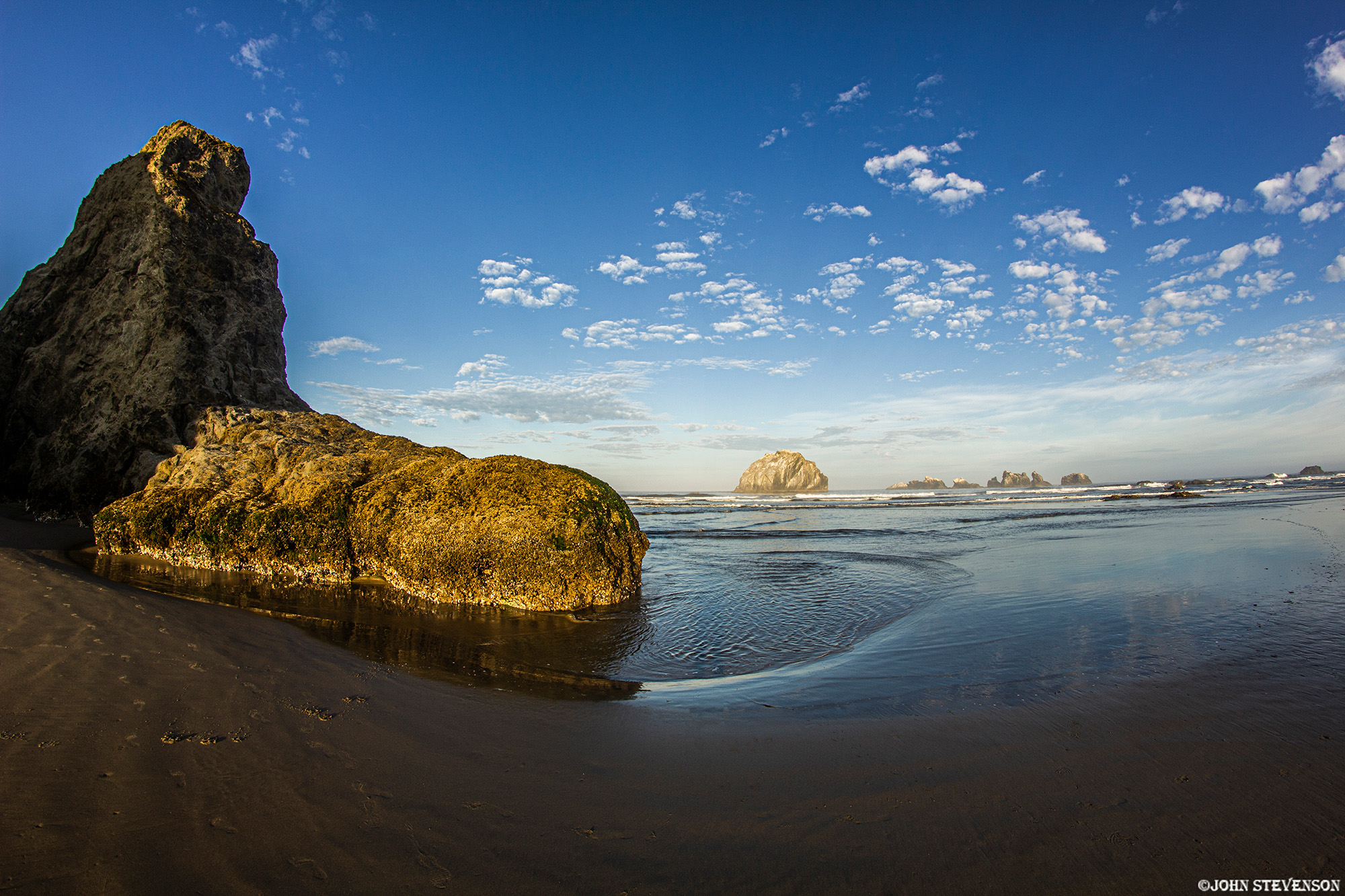 Swerling Waters Bandon Beach Oregon Coast Bandon Beach on the Oregon Coast, with dramatic sea stacks rising from the ocean and waves along the sandy shoreline.